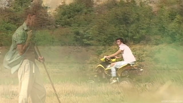 Guy on ATV Follows Farm Boy in his Field