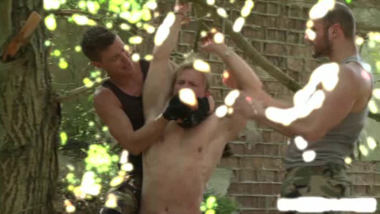 2 men use a slave strung up from a tree