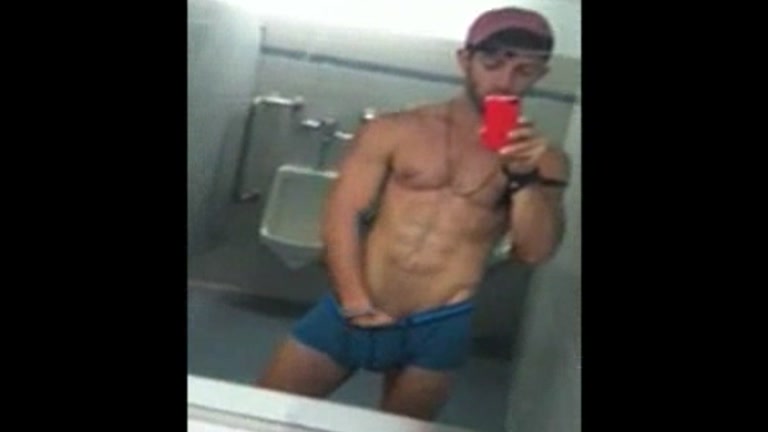 ripped stud takes a mirror selfie in public toilet