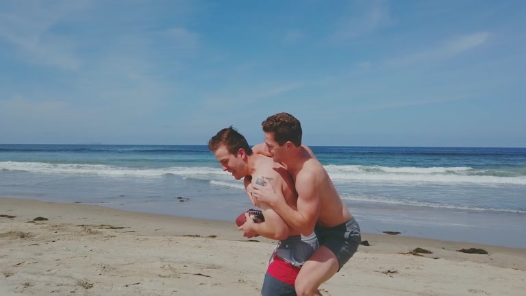 hunky jocks toss a football on the beach & go home to fuck