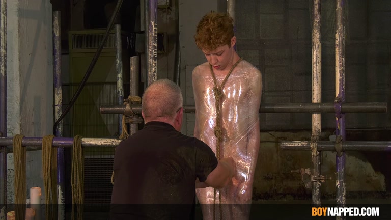 twink mummified in plastic wrap then bound with rope