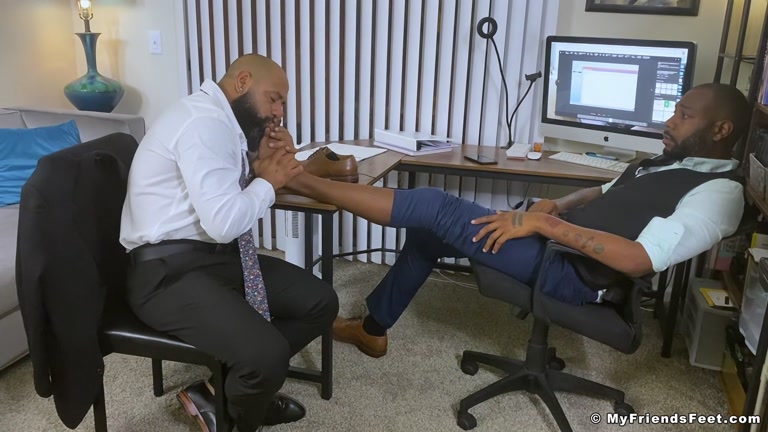 Bearded Man Works Over his Employee's Feet at His Desk