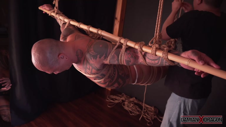 inked man suffers in rope bondage agony