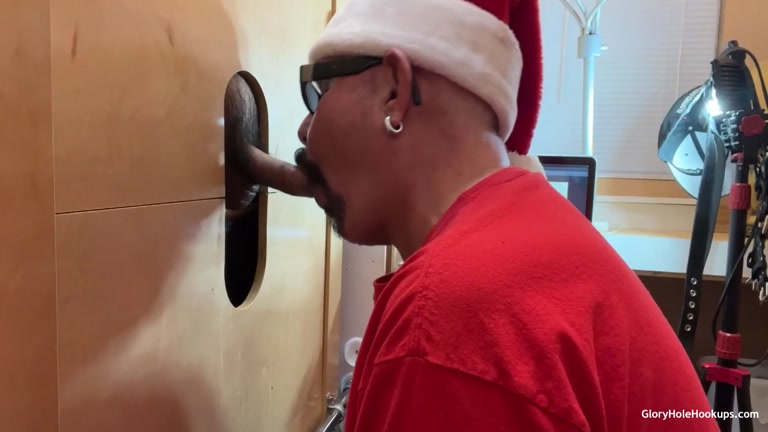 man in santa hat sucking glory hole dick