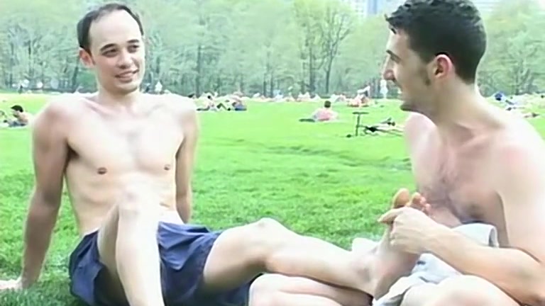 Guy Rubs Friend's Bare Feet Outdoors