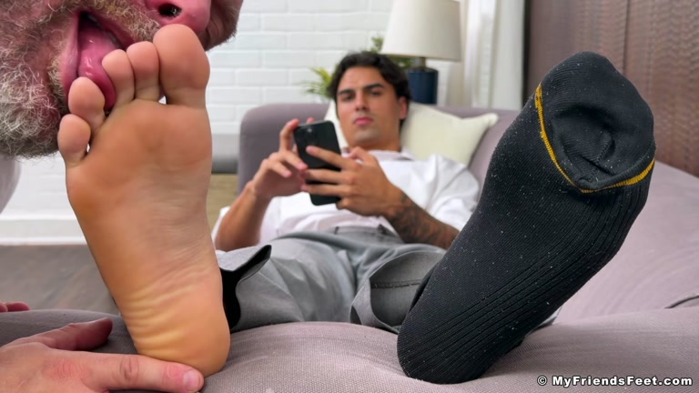 Young Stud Looks at Phone Porn While Daddy Worships His Feet