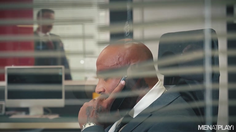 Executive Strokes Cock at Desk Unaware That He's Being Watched